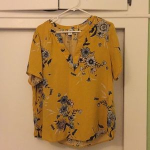 Gold blouse with floral pattern.